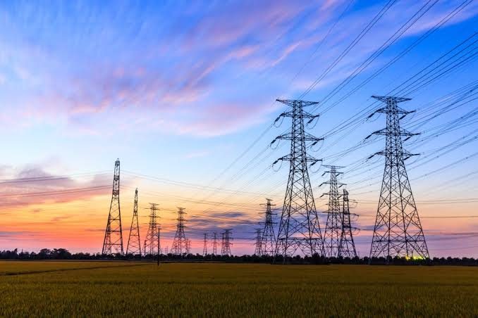 Overhead transmission towers at sunset